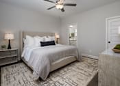 Thumbnail 40 of 44 - A bedroom with a large bed and a ceiling fan.