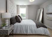 Thumbnail 41 of 44 - A bedroom with a large bed and a painting on the wall.
