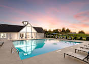Thumbnail 34 of 44 - A swimming pool in front of a house with sunset in the background.