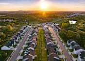 Thumbnail 32 of 44 - A sunset view of a residential neighborhood with houses and streets.