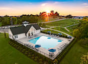 Thumbnail 1 of 44 - A beautiful sunset over a pool and a house.