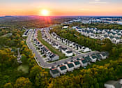 Thumbnail 29 of 44 - A sunset view of a residential area with houses and trees.
