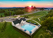 Thumbnail 25 of 44 - A house with a pool surrounded by a green lawn.