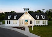 Thumbnail 28 of 44 - A white house with a black roof and a tower on top.