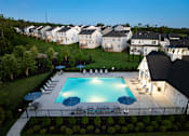 Thumbnail 15 of 44 - A swimming pool surrounded by a black fence and several chairs.