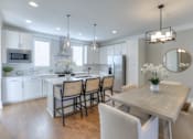 Thumbnail 1 of 32 - A modern kitchen with a dining table and chairs.