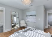 Thumbnail 28 of 32 - A bedroom with a large bed, a chair, and a painting on the wall.