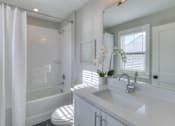 Thumbnail 30 of 32 - A white bathroom with a toilet, sink, and shower.