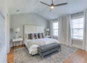 Thumbnail 27 of 32 - A bedroom with a large bed and a ceiling fan.