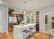 Thumbnail 1 of 15 - Kitchen with island, white quartz counters and dark cabinets at ALARA Union Station Apartment Homes, Denver, 80202