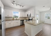 Thumbnail 23 of 47 - A kitchen with white cabinets and a granite countertop.