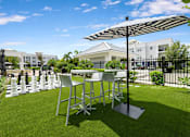 Thumbnail 41 of 47 - A table and chairs set up on a lawn with a chess board in the middle.