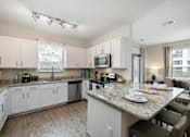 Thumbnail 20 of 47 - A kitchen with a table set for two.