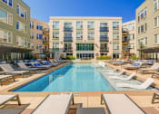 Thumbnail 7 of 15 - a swimming pool with lounge chairs in front of at ALARA Union Station Apartments in Denver, 80202