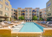 Thumbnail 14 of 15 - Swimming pool with lounge chairs at ALARA Union Station Apartments in Denver, 80202