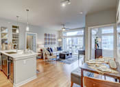 Thumbnail 3 of 15 - A modern kitchen with a dining table and chairs.