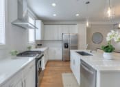 Thumbnail 2 of 23 - a white kitchen with stainless steel appliances and white counters