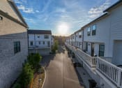 Thumbnail 23 of 23 - the sun sets over a street between rows of houses