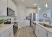 Thumbnail 14 of 14 - a kitchen with white cabinets and stainless steel appliances