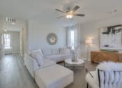 Thumbnail 10 of 14 - a living room with a white couch and a ceiling fan