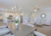 Thumbnail 8 of 14 - a living room with couches and a dining table