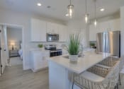 Thumbnail 11 of 14 - a kitchen with white cabinets and a counter top