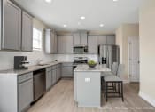 Thumbnail 4 of 51 - a kitchen with gray cabinets and stainless steel appliances and an island with white counter tops