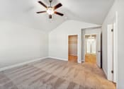 Thumbnail 44 of 50 - Primary bedroom with carpet, ceiling fan and large walk-in closet.