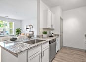 Thumbnail 17 of 47 - A kitchen with a marble countertop and stainless steel appliances.