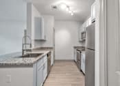Thumbnail 19 of 47 - A kitchen with a marble countertop and stainless steel appliances.