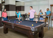 Thumbnail 19 of 38 - People playing billiards at The Bartram Apartments in Gainesville, FL 32608