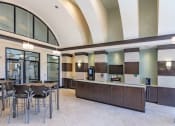 Thumbnail 17 of 38 - Clubhouse Cafe with seating area. Starbucks coffee machine and self serve coffee bar available 24/7 at The Bartram Apartments in Gainesville, FL 32608