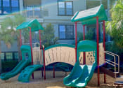 Thumbnail 13 of 38 - Toddler playground with 4 slides and agility half tunnel at The Bartram Apartments in Gainesville, FL 32608