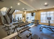 Thumbnail 25 of 38 - Weight room with benches and peloton bicycle at The Bartram Apartments in Gainesville, FL 32608