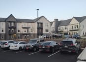 Thumbnail 26 of 30 - a parking lot full of cars in front of an apartment building