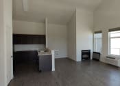 Thumbnail 14 of 30 - an empty living room with a kitchen in the background
