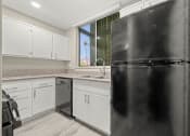 Thumbnail 14 of 15 - a kitchen with white cabinets and a black refrigerator