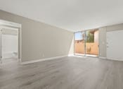 Thumbnail 8 of 15 - a bedroom with hardwood floors and a sliding glass door to a patio