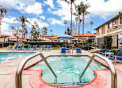 Thumbnail 5 of 30 - A pool and jacuzzi with a red and green design in the middle of it.