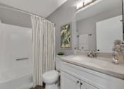 Thumbnail 5 of 43 - a bathroom with a shower and a sink and a toilet