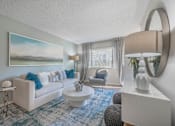 Thumbnail 8 of 30 - a living room with a white couch and a blue rug