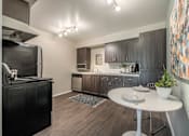 Thumbnail 3 of 30 - a kitchen with black appliances and a white table