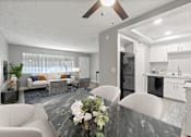 Thumbnail 2 of 15 - A modern kitchen with a dining table set in the middle.