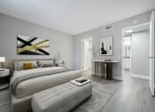 Thumbnail 6 of 20 - A modern bedroom with a large bed and a painting on the wall.