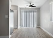 Thumbnail 16 of 21 - A room with a ceiling fan and a window with vertical blinds.