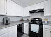 Thumbnail 13 of 21 - A black stove top oven with a white towel on it.