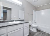 Thumbnail 21 of 21 - A bathroom with a toilet, sink, and mirror.
