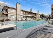 Thumbnail 5 of 21 - A swimming pool surrounded by a fence and chairs.