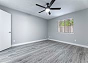 Thumbnail 8 of 15 - a bedroom with hardwood floors and a ceiling fan