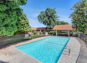 Thumbnail 9 of 15 - a swimming pool with a gazebo and trees in the background